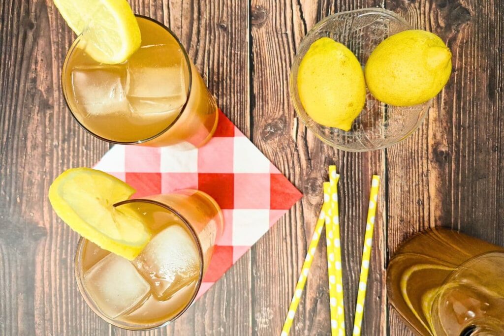 overhead view of two glasses filled with sweet tea vodka lemonade plus lemons and straws