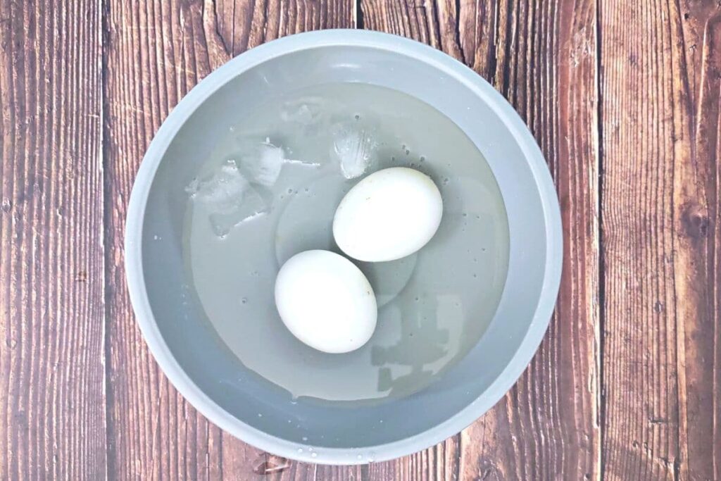 place cooked eggs in ice bath