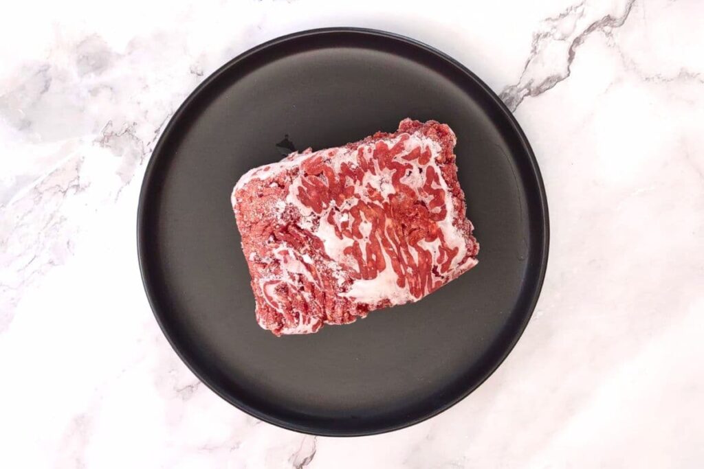 place frozen beef on a microwave safe plate with a lip
