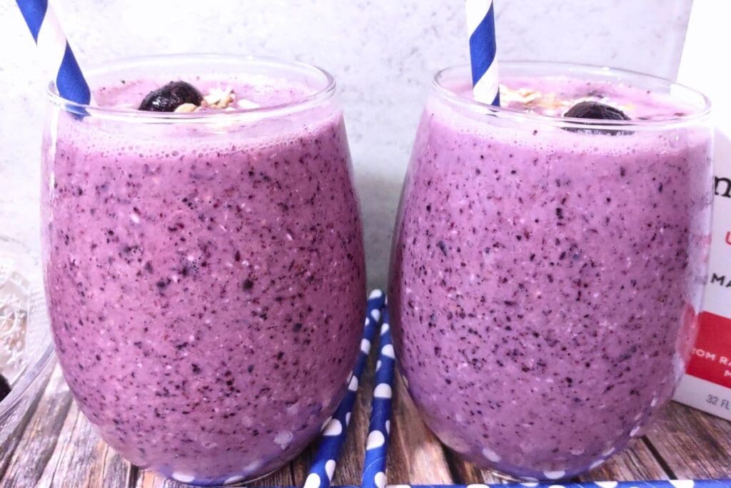 two blueberry pie smoothies with blue striped straws side by side