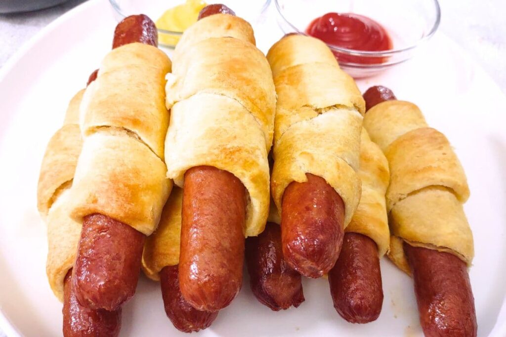 air fryer crescent dogs stacked up on a plate