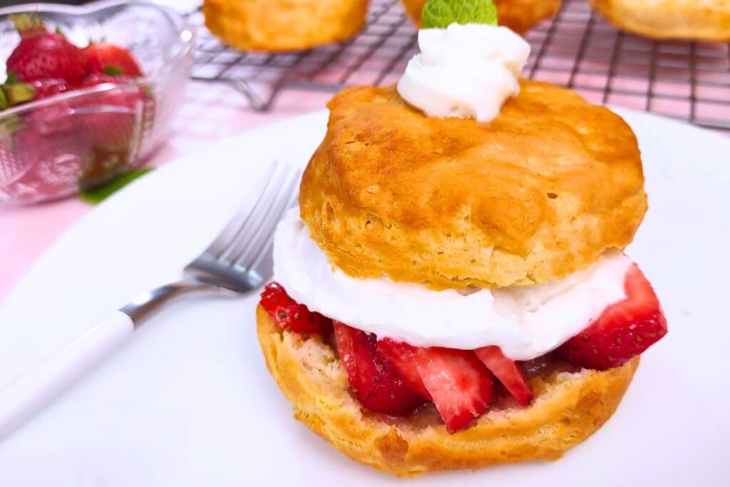 closeup of strawberry shortcake on a plate with whipped cream