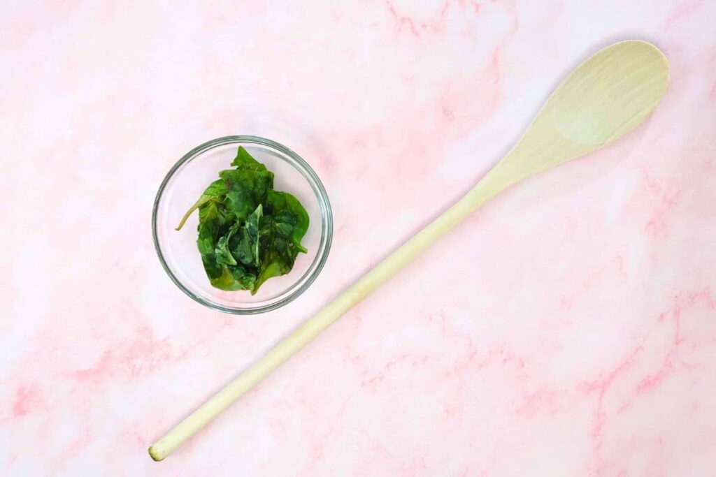 muddle the basil leaves with a wooden spoon