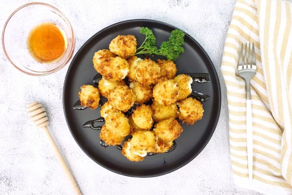 overhead view of air fryer goat cheese balls on a plate with honey