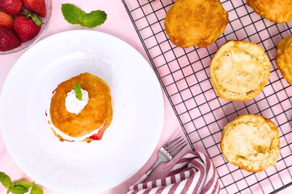 overhead view of air fryer strawberry shortcake on a plate with fresh biscuits