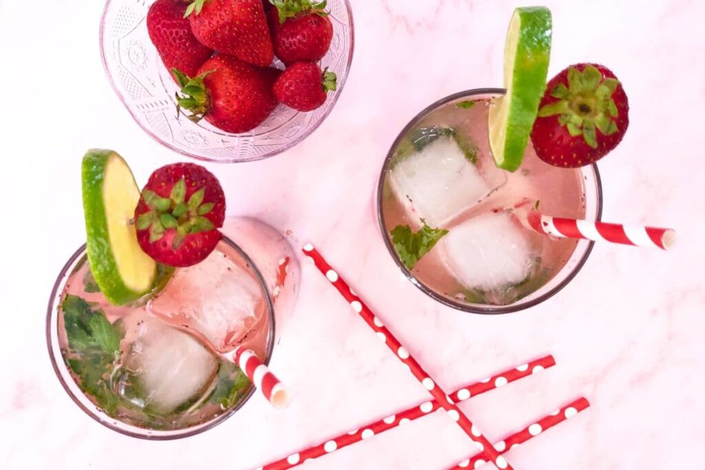 overhead view of strawberry basil mojitos with paper straws scattered around