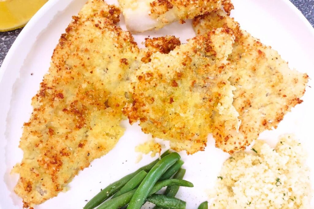 parmesan crusted cod cooked in the air fryer on a plate with vegetables