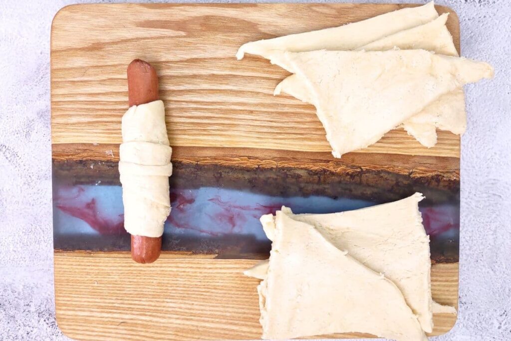 roll hot dog over the dough and pinch closed