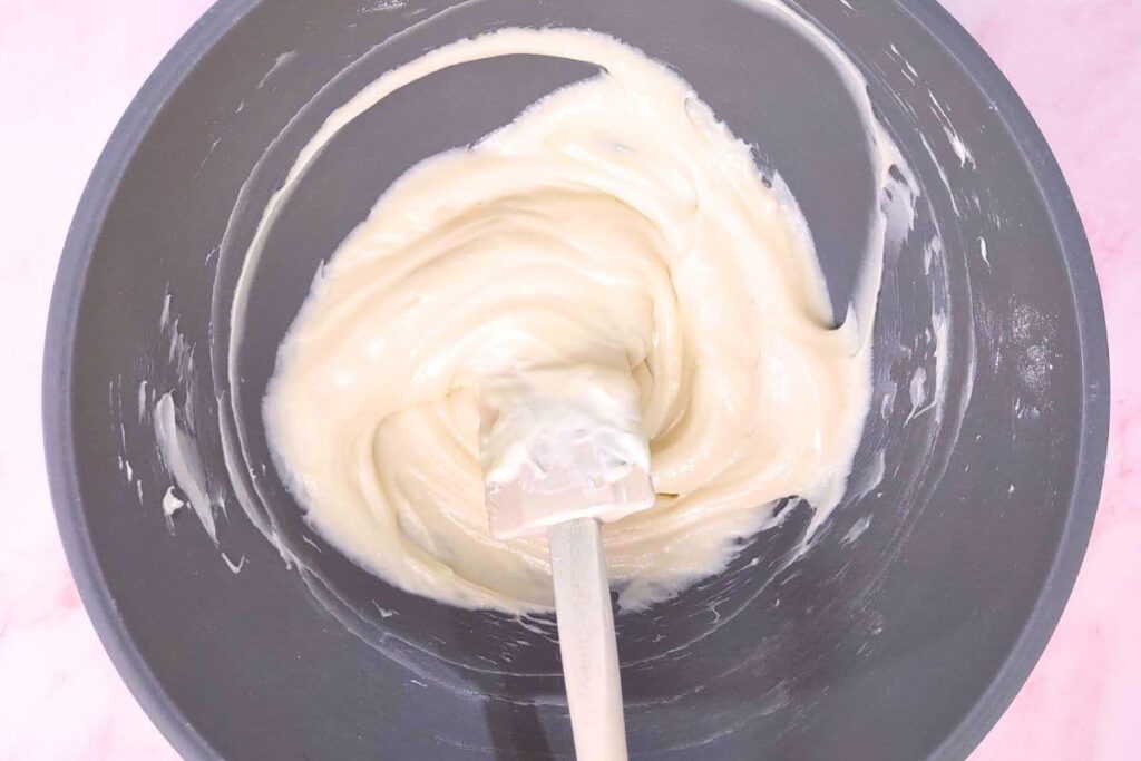 stir the softened cream until smooth and fold in sugar and vanilla