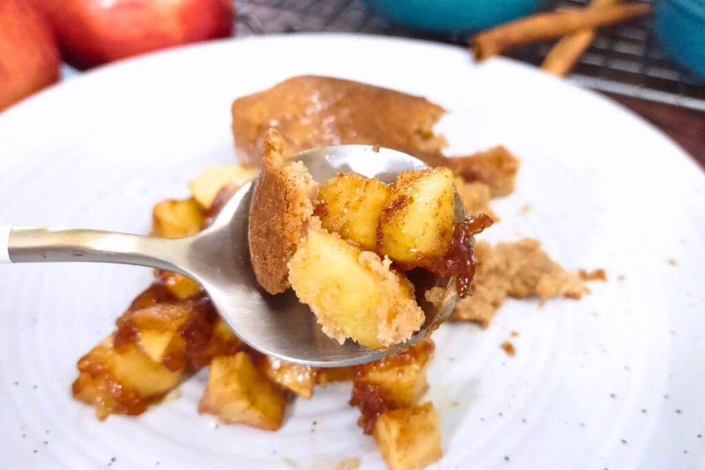 holding up a spoonful of air fryer apple cobbler