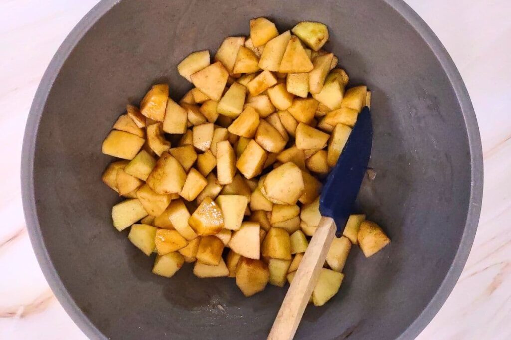 mix apple chunks with cinnamon, sugar, and bourbon in a bowl