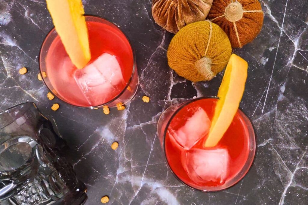 overhead view of two headless horseman cocktails garnished with orange slices