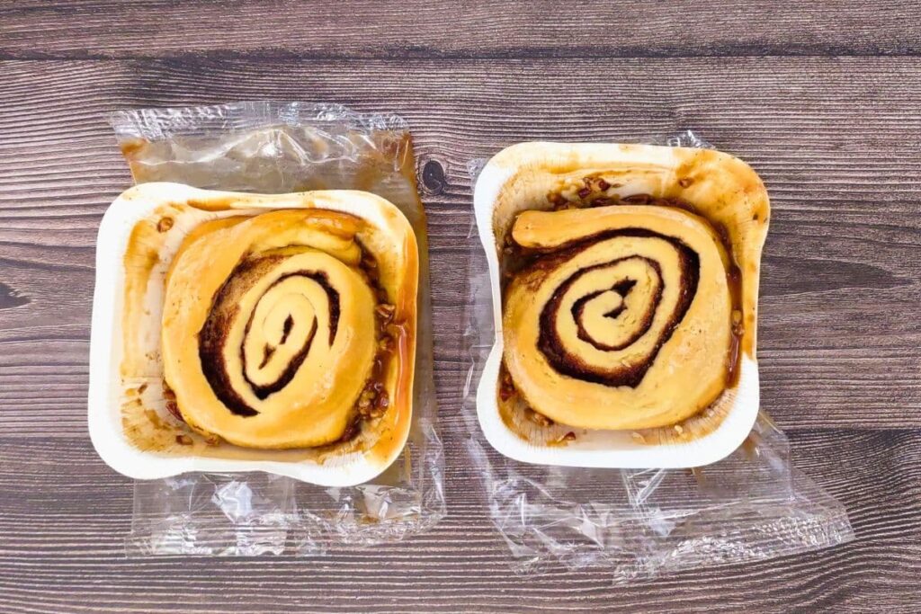 remove cinnabon pecan rolls from plastic but keep them in the trays