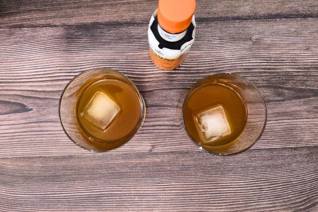 add an ice cube and bitters to the pumpkin spice bourbon