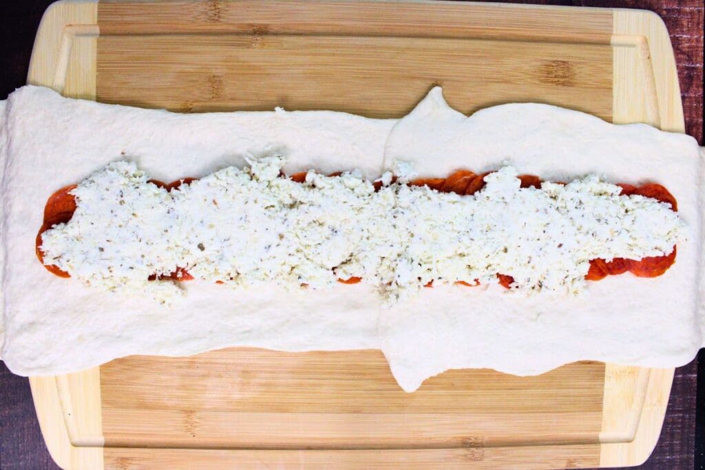 add pepperoni and cheese filling to the center of the long dough shape