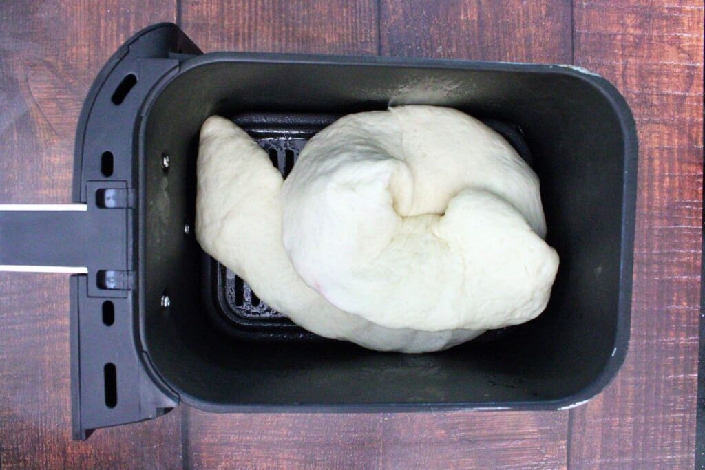curl calzone dough to form a snake in the air fryer basket