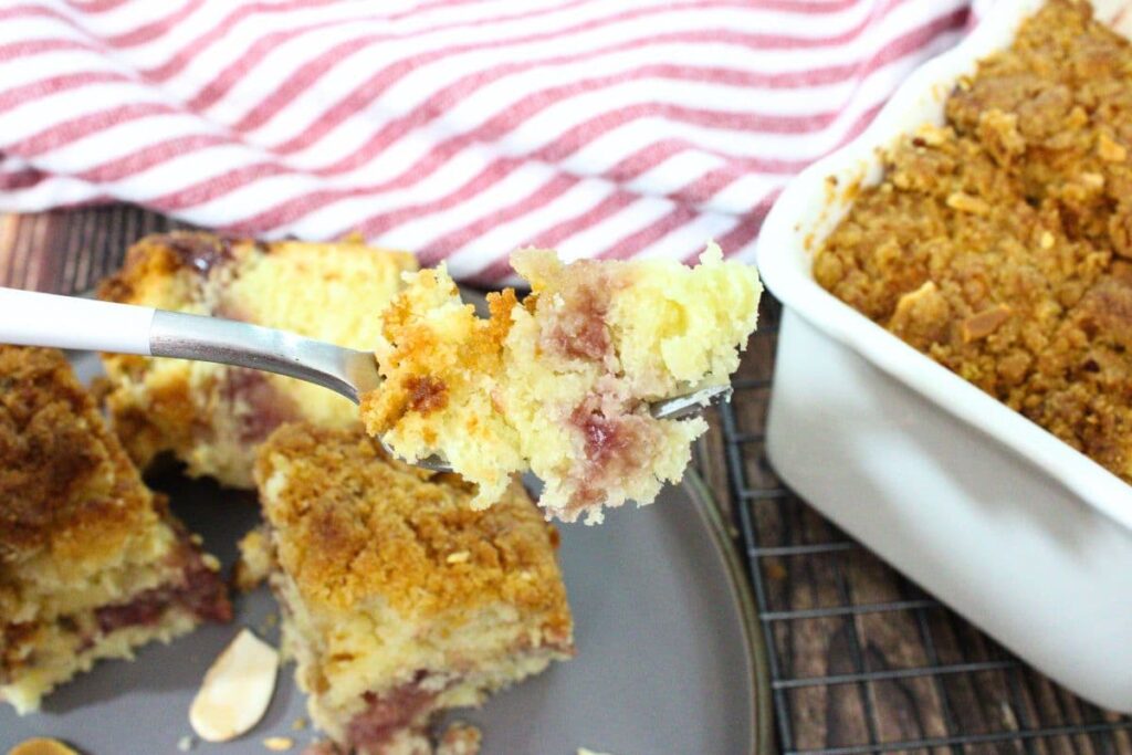 holding up a forkful of air fryer coffee cake with raspberry filling