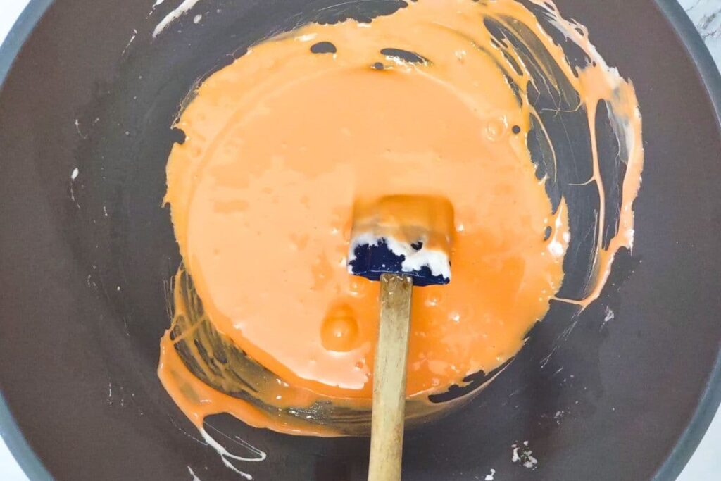 mix food coloring to turn the melted marshmallows orange