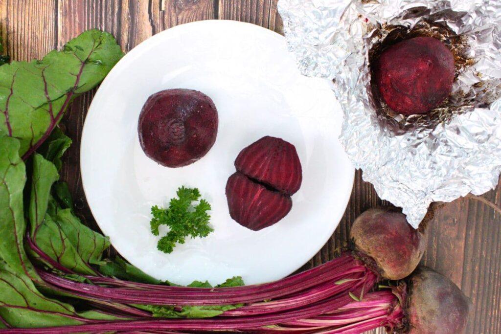 overhead view of air fryer whole roasted beets on a plate and in aluminum foil