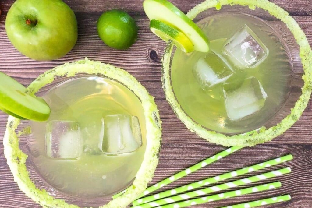 overhead view of two sour green apple margaritas