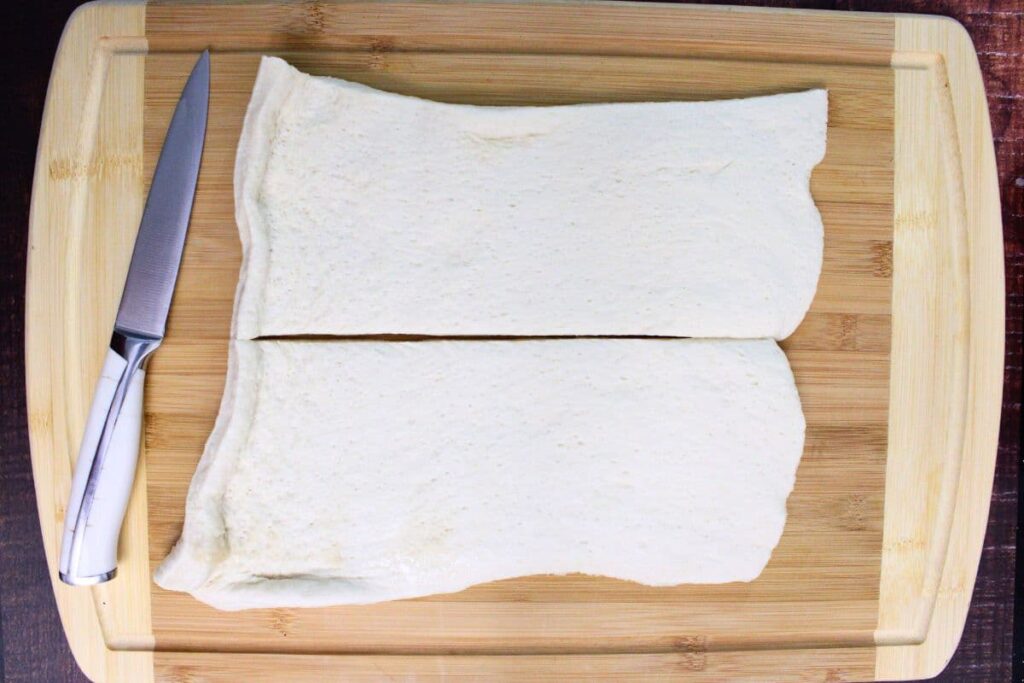 roll pizza dough flat and slice lengthwise