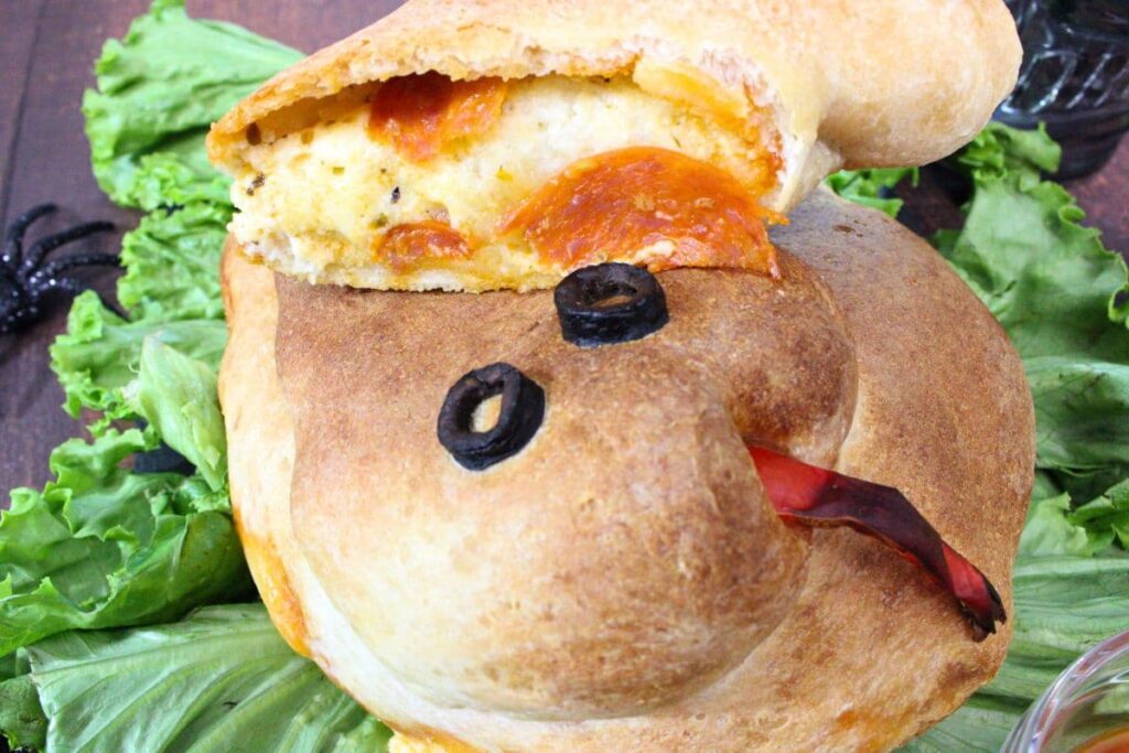 snake calzone facing you with a slice of pepperoni and ricotta filling visible