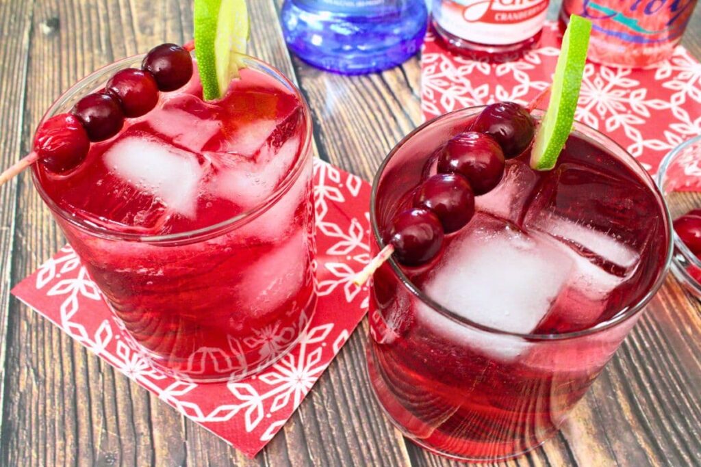two glasses of bubbly vodka cranberry fizz drinks with lime