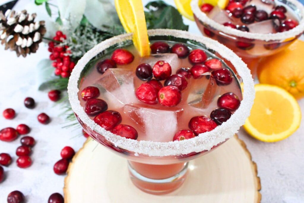 cranberry orange margarita christmas and holiday cocktail surrounded by festive winter decorations