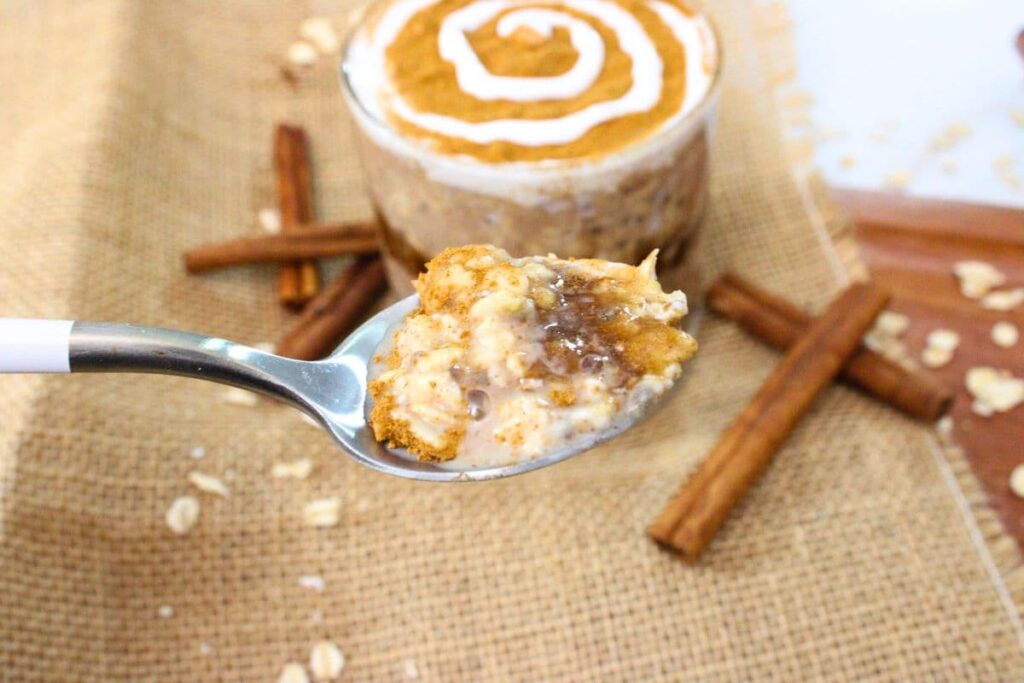 holding up a spoonful of cinnamon roll overnight oats
