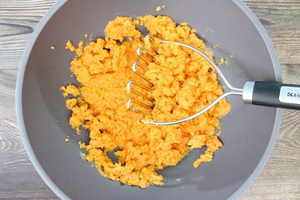 mash sweet potatoes using a potato masher