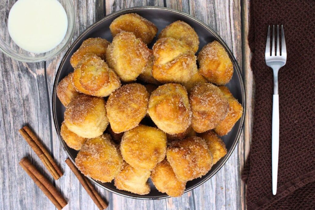 overhead view of air fryer cinnamon roll bites made with canned biscuits