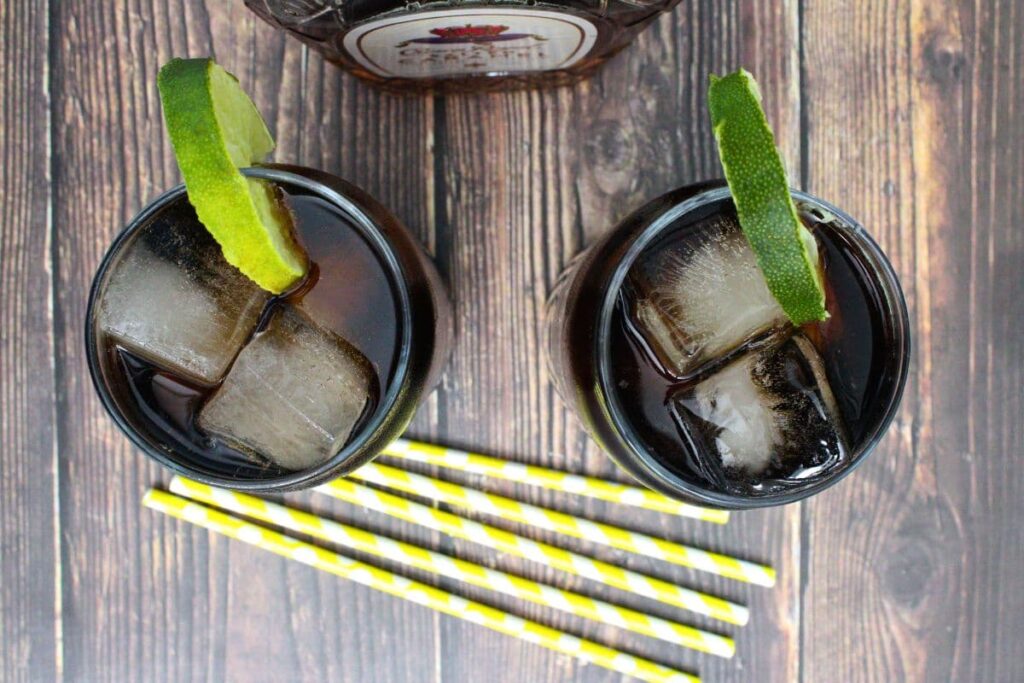 overhead view of two glasses of salted caramel crown and coke with lime slices