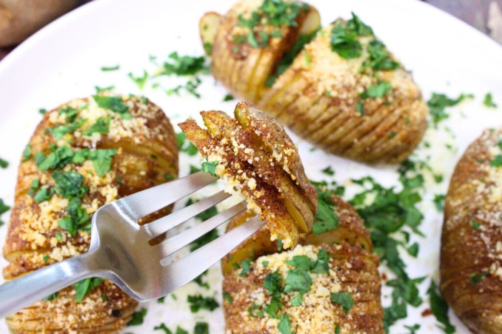 several slices of microwave hasselback potatoes on a fork