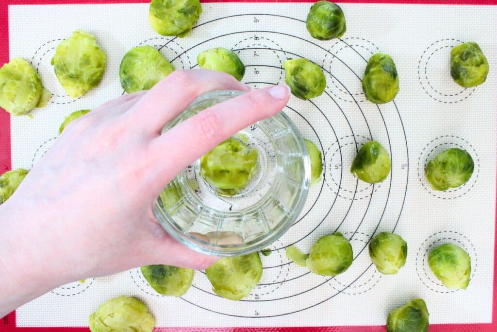 smash the cooked brussel sprouts flat using a glass