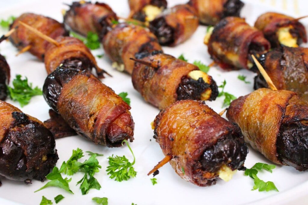 closeup of several air fryer goat cheese stuffed bacon wrapped dates with toothpicks