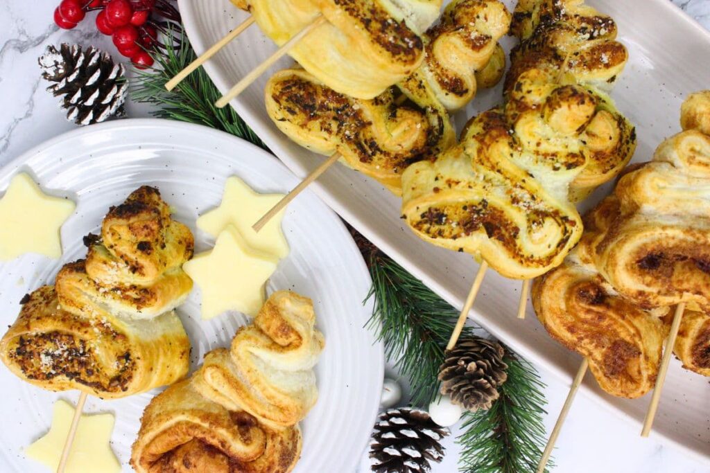 overhead view of savory and sweet air fryer mini puff pastry christmas trees on a plate and holiday platter