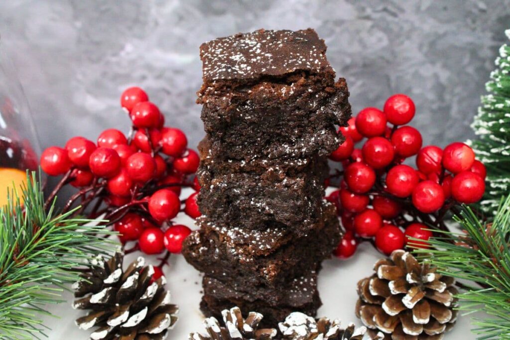 stacked up mulled wine brownies surrounded by winter holiday decorations