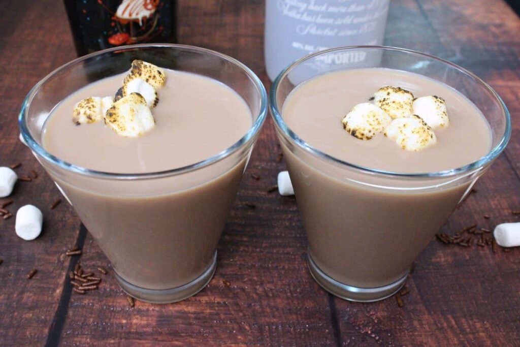 two glasses filled with hot chocolate martinis topped with marshmallows