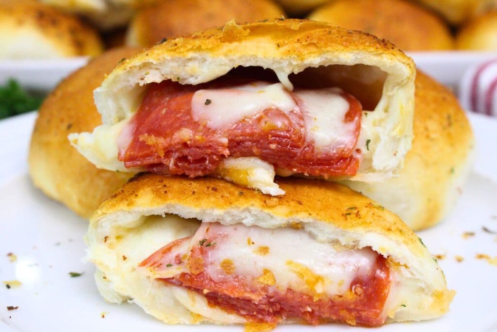 air fryer pizza bomb split in half with pepperoni and mozzarella cheese spilling out