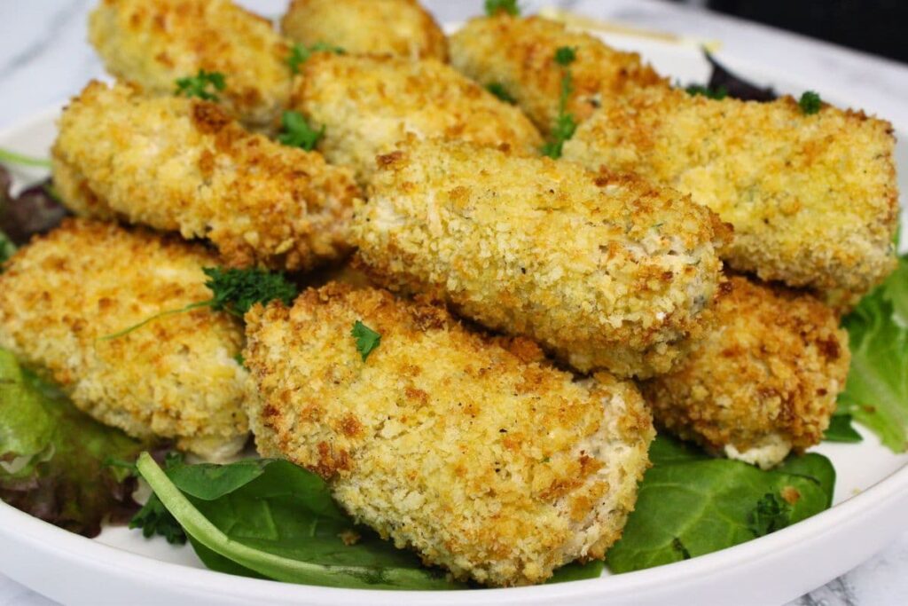closeup view of air fryer chicken croquettes on a plate of greens