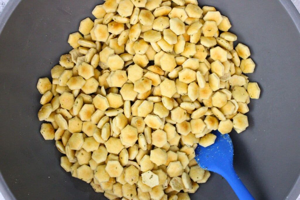 in a large mixing bowl combine oyster crackers with oil and seasoning mix