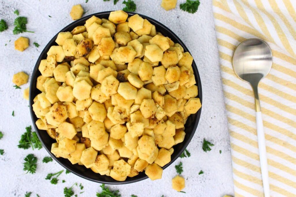 overhead view of air fryer oyster crackers in a bowl with a spoon to the side