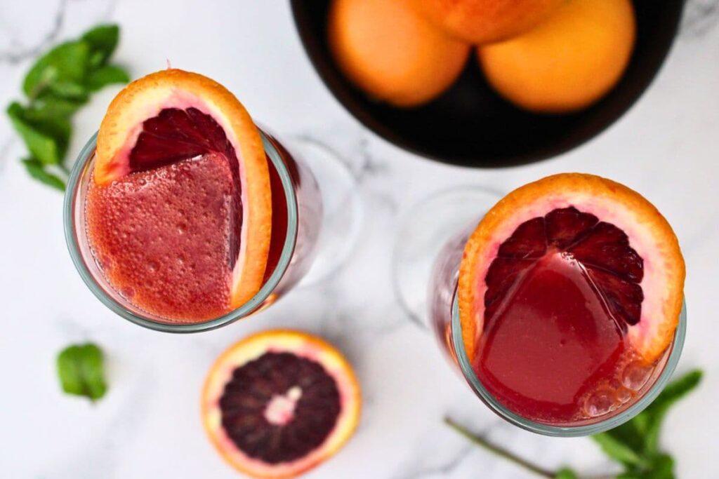 overhead view of blood orange mimosas with blood orange slices folded inside
