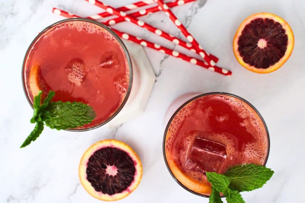 overhead view of blood orange vodka cocktails surrounded by paper straws