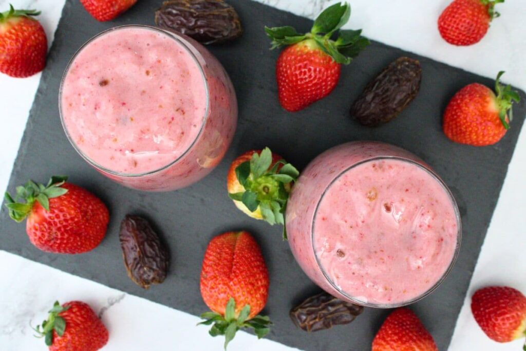 overhead view of strawberry date smoothies with fresh fruit