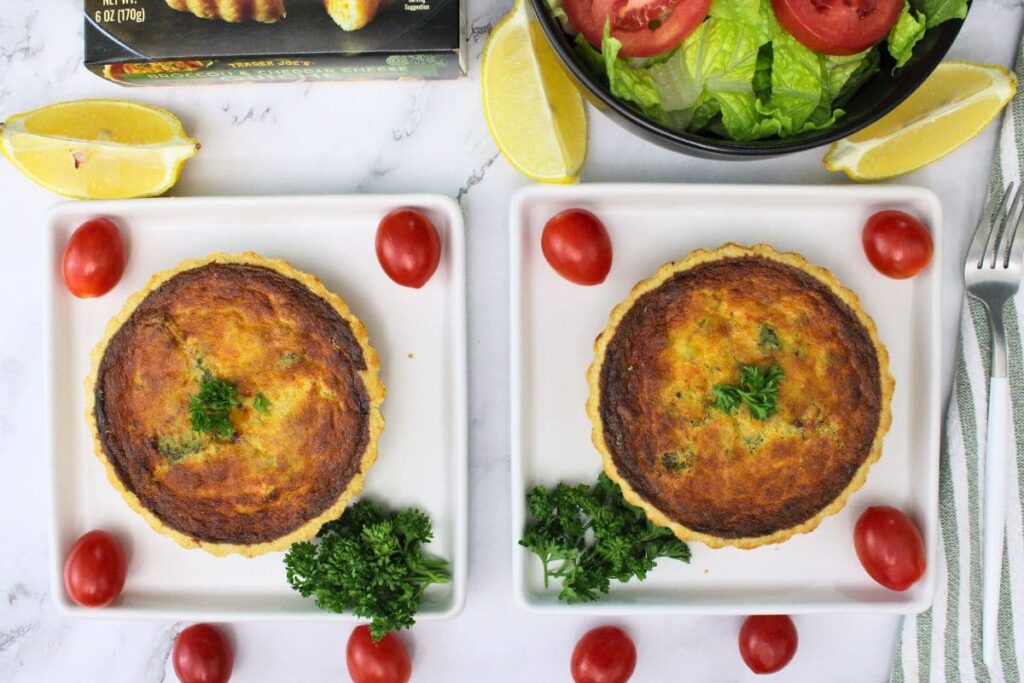 overhead view of two trader joes broccoli cheddar quiche on square plates