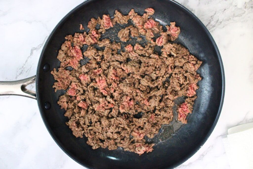 partially brown ground beef in skillet