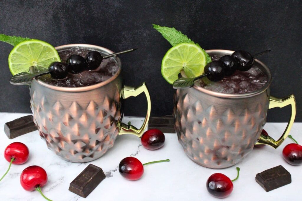 two chocolate cherry mules in copper mugs against a dark background