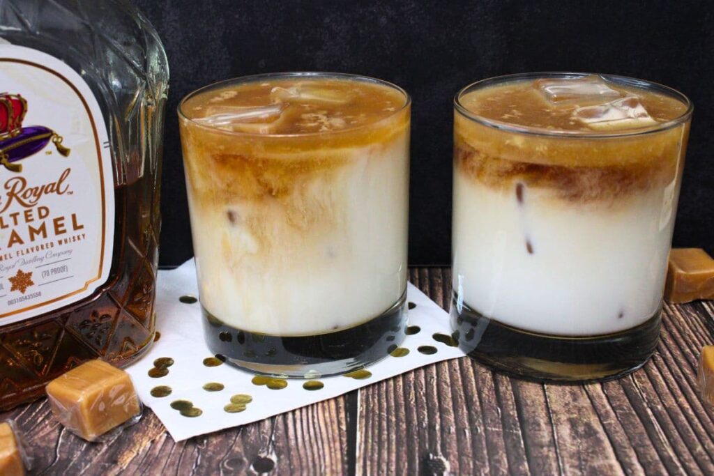 two glasses of crown royal salted caramel white russian drinks against a dark background