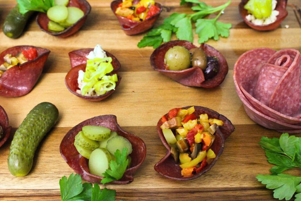 wooden platter filled with air fryer salami cups stuffed and surrounded by antipasti